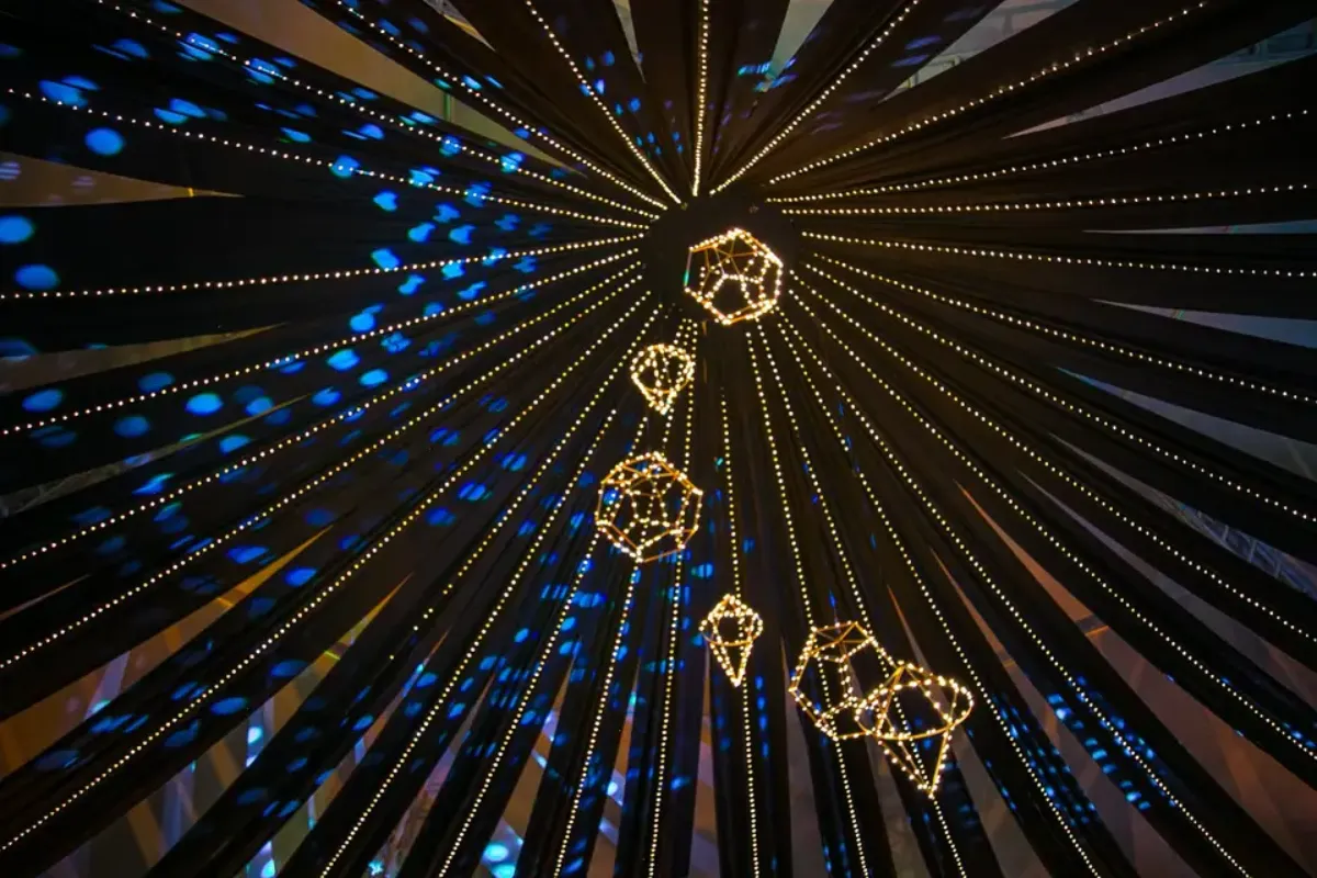 Rosetón de telas con hilos de luz y figuras doradas